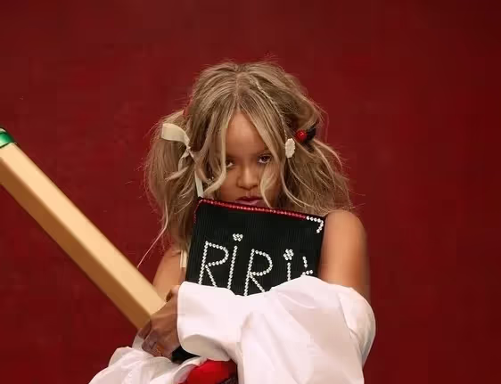 Portrait of Rihanna hiding behind 'Riri's Book' in PumaxFenty campaign in support of new Creeper Phatty Shoes collaboration