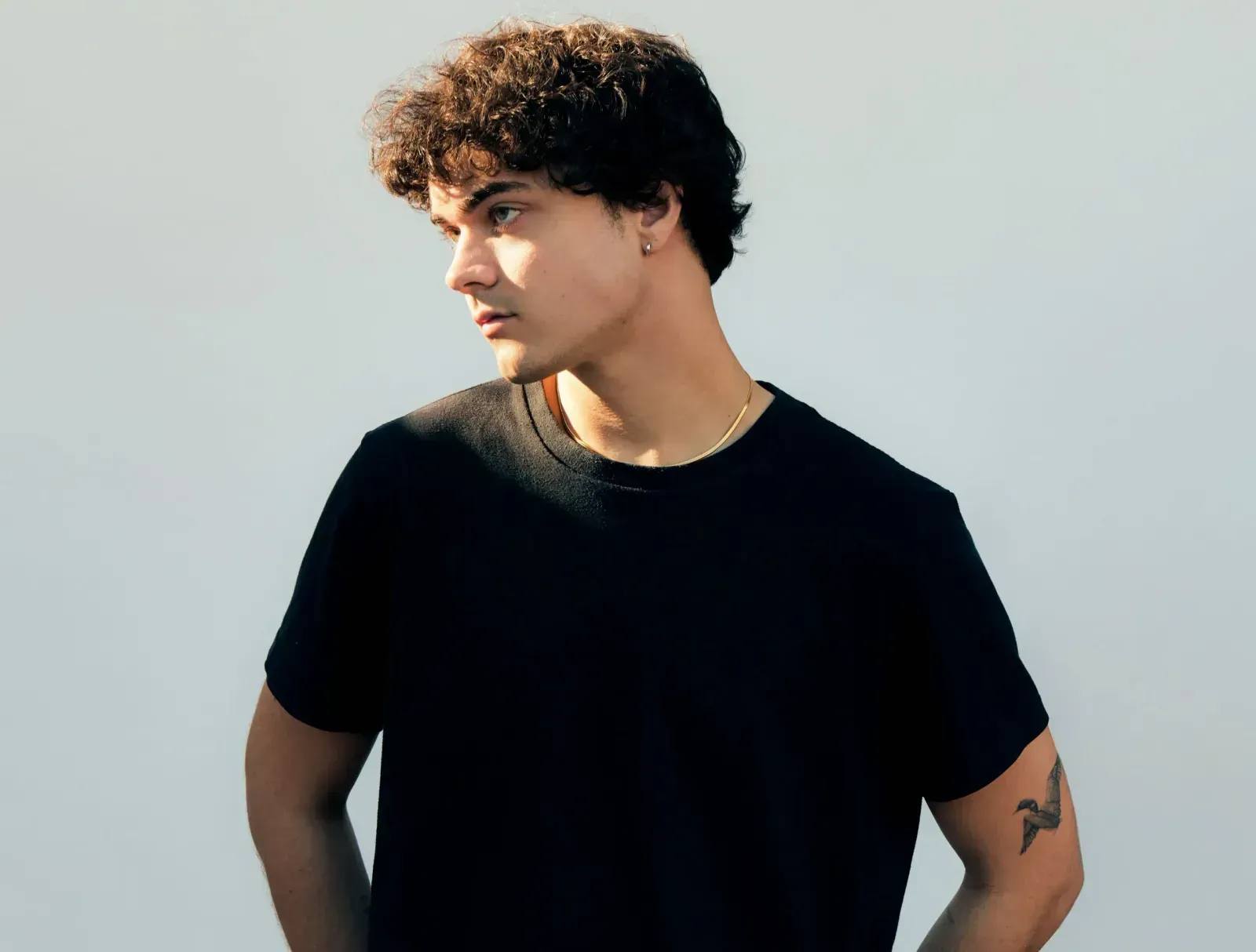 Alexander Stewart wearing black top on a white background.