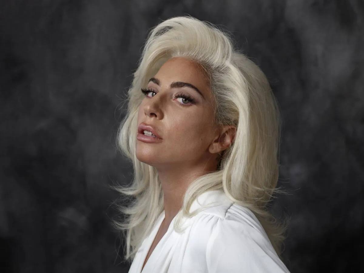 Lady Gagin portret, noseći bijeli odijelo na tamnoj sivoj pozadini