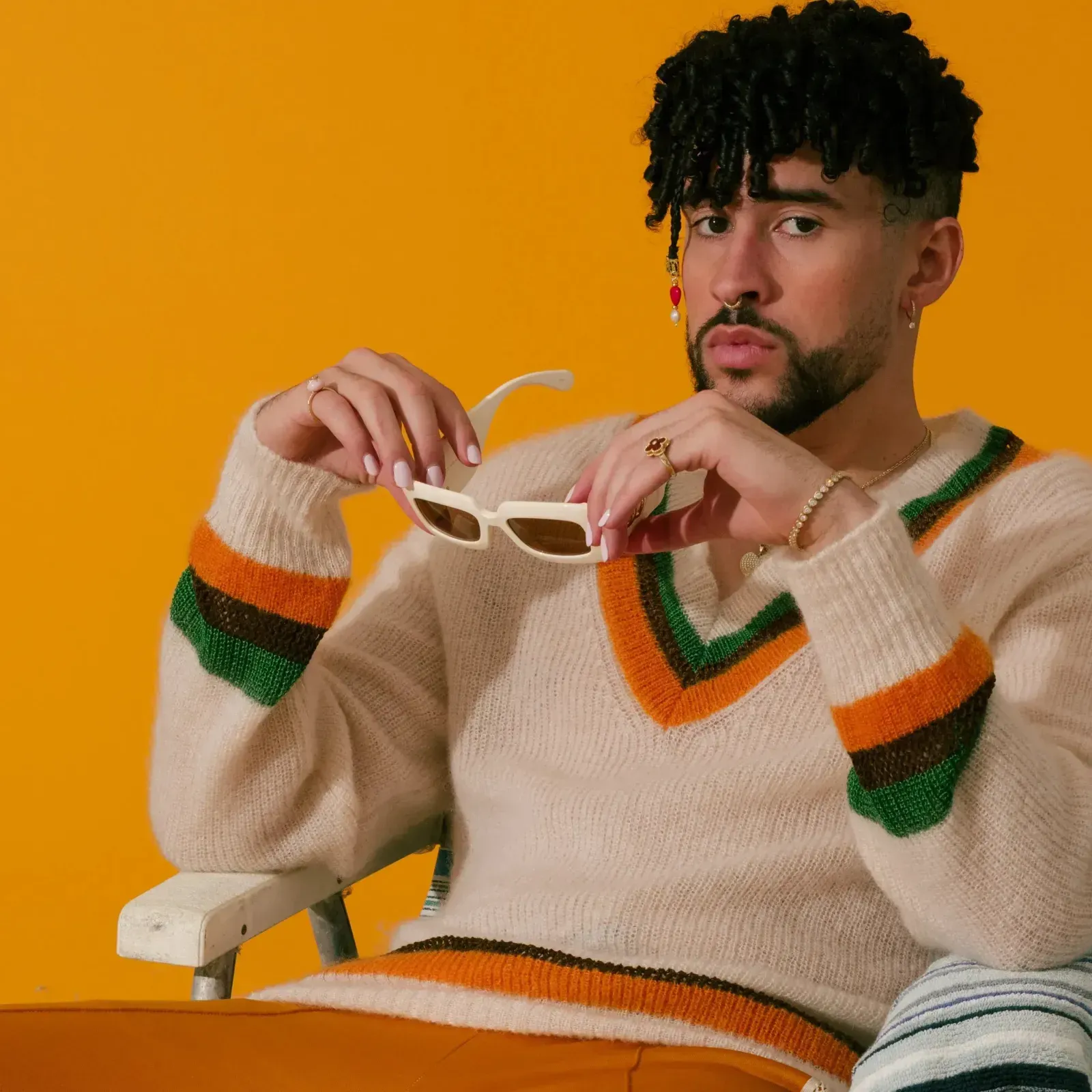 Bad Bunny with curly hair, wearing a sweater as he earns Guinness World Record for most streamed album of 2023
