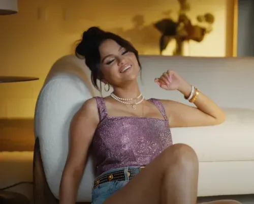 Selena Gomez wearing a sparklingh purple top and jeans shirts with 'S' pearl necklace in 'Single Soon' Music video