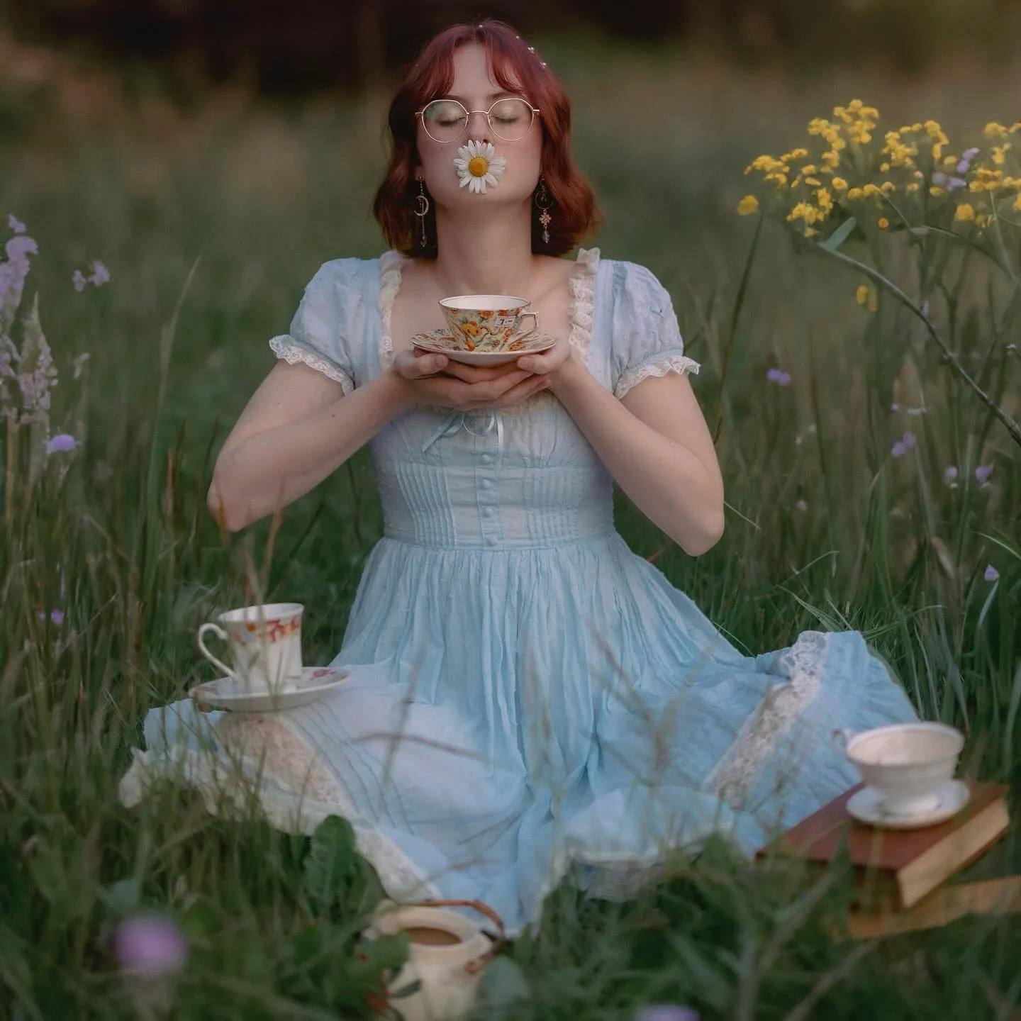 PEGGY (Peggy Owens) in a sky blue dress, tea party in a field, chamomile in her lips.