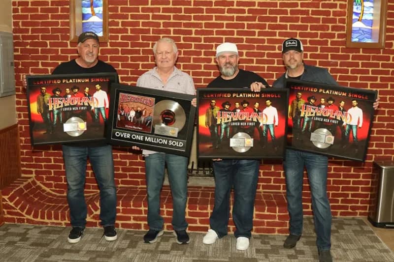 Herb Graham of Graham Artist Management presents Heartland with Platinum plaques for "I Loved Her First"