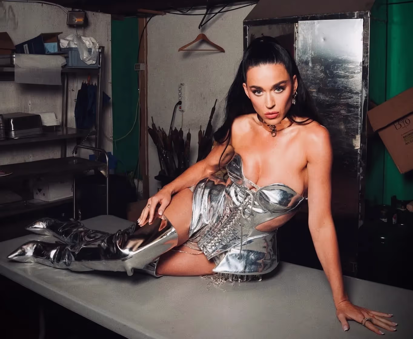 Katy Peery dressed in silver metallic corset and over the knee silver leather boots, artist profile, bio