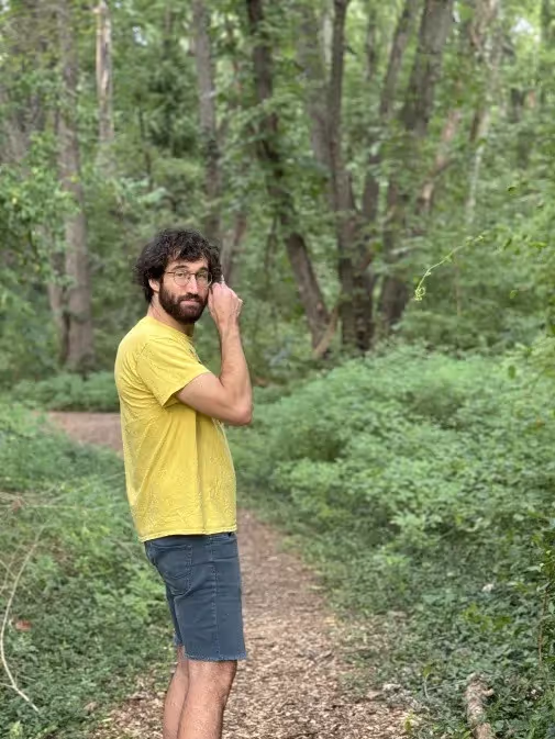 Joe Mygen, hiking in forest, jeans shorts, bright yellow t-shirt, Photo: Corinne Cooke