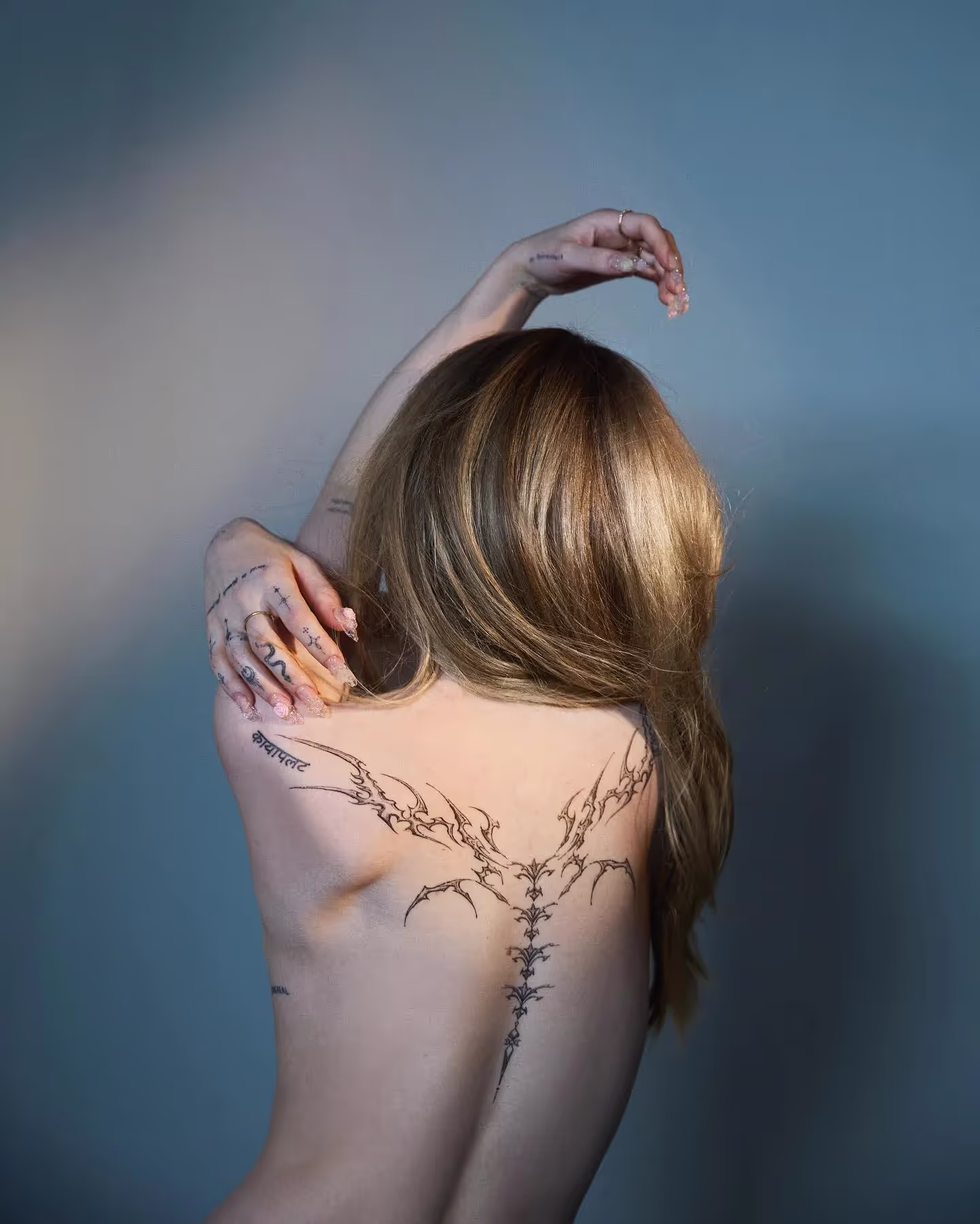 Dove Cameron flaunts her full back tattoo in a new photo series.