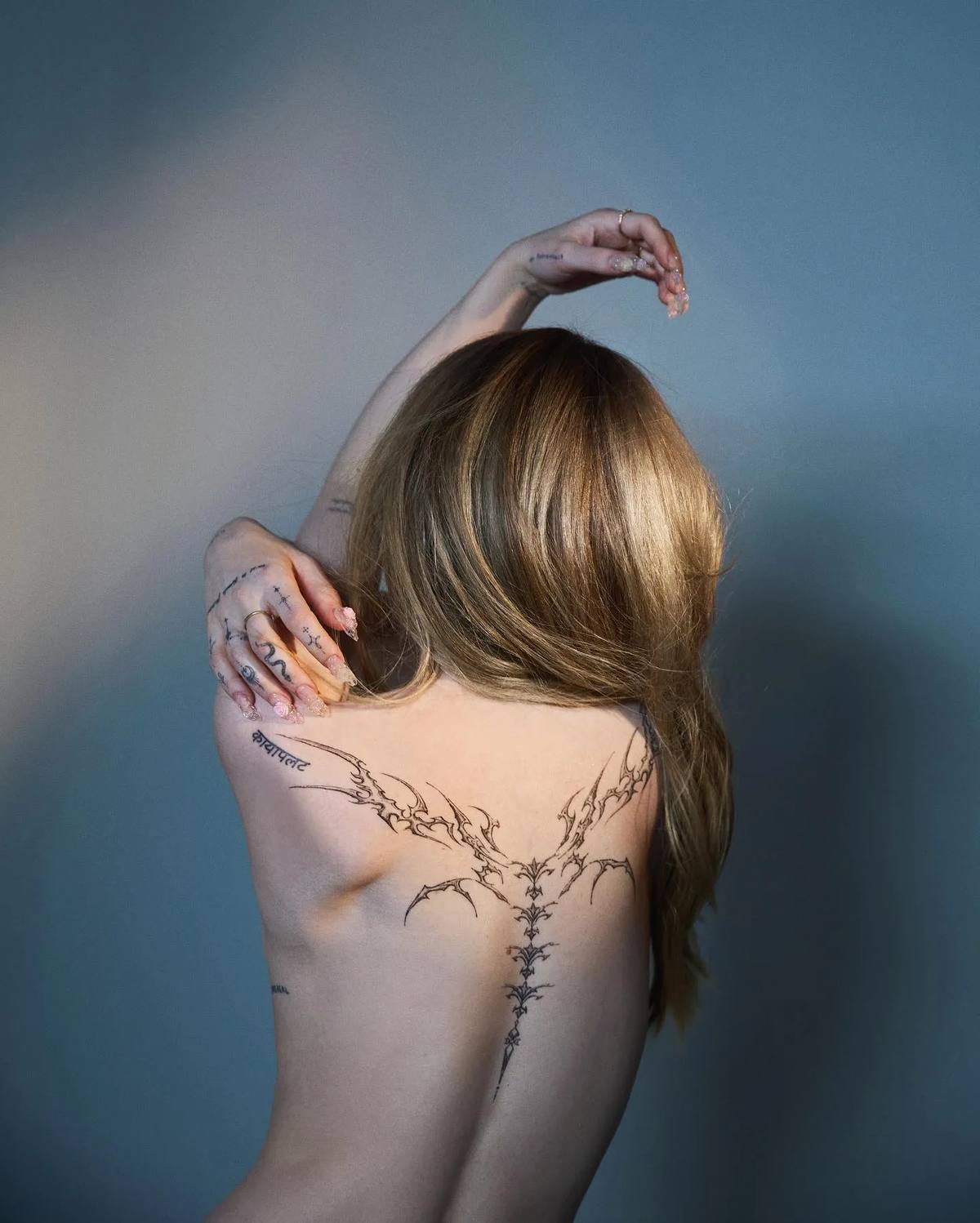 Dove Cameron flaunts her full back tattoo in a new photo series.