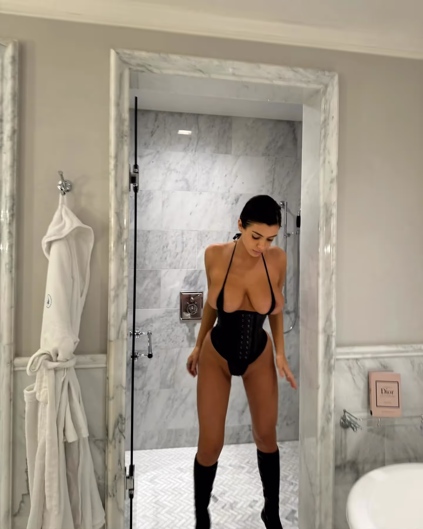 Kanye West (Ye) posts image of Bianca Censori in a tiny bra barely covering her nipples, small underwear and a black leather corset in a hotel bathroom (Via Ye's IG feed)