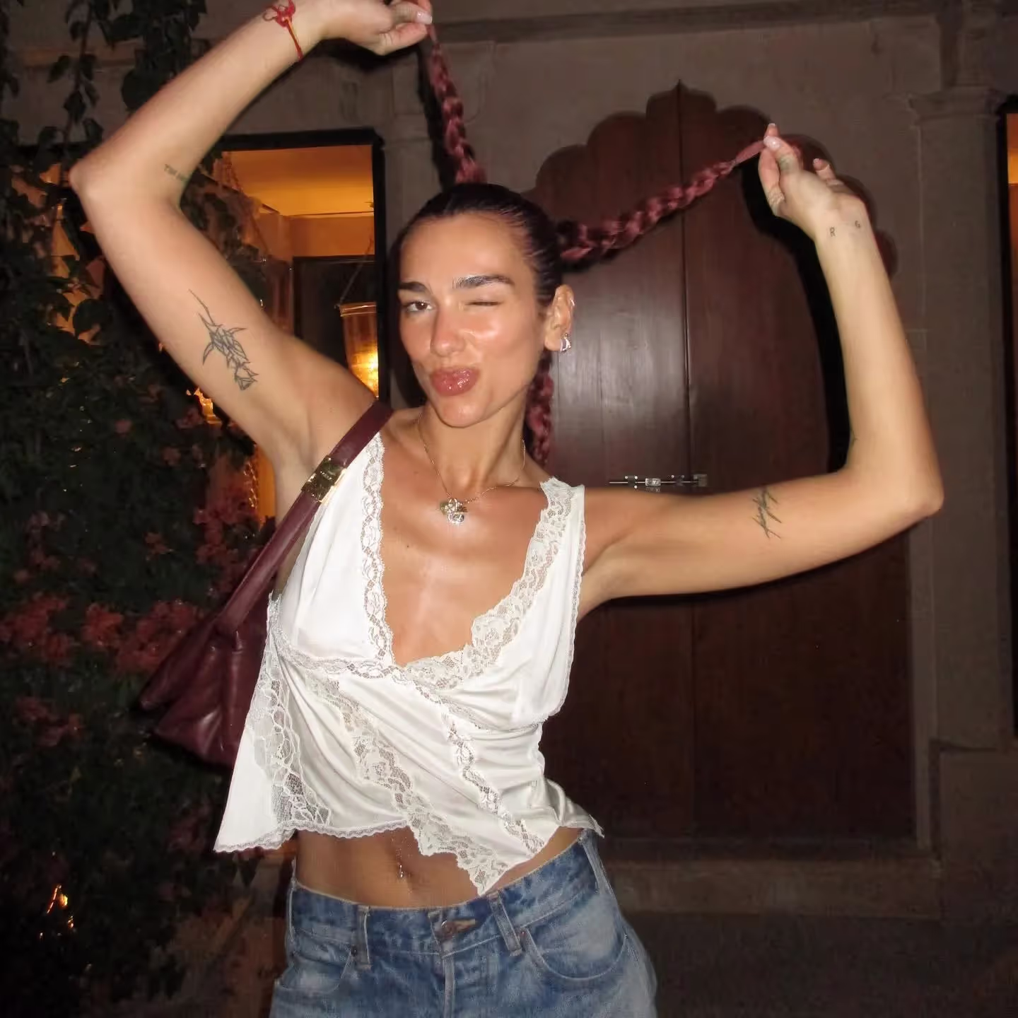 Happy Dua Lipa with red haired braid on holiday vacation with family in India