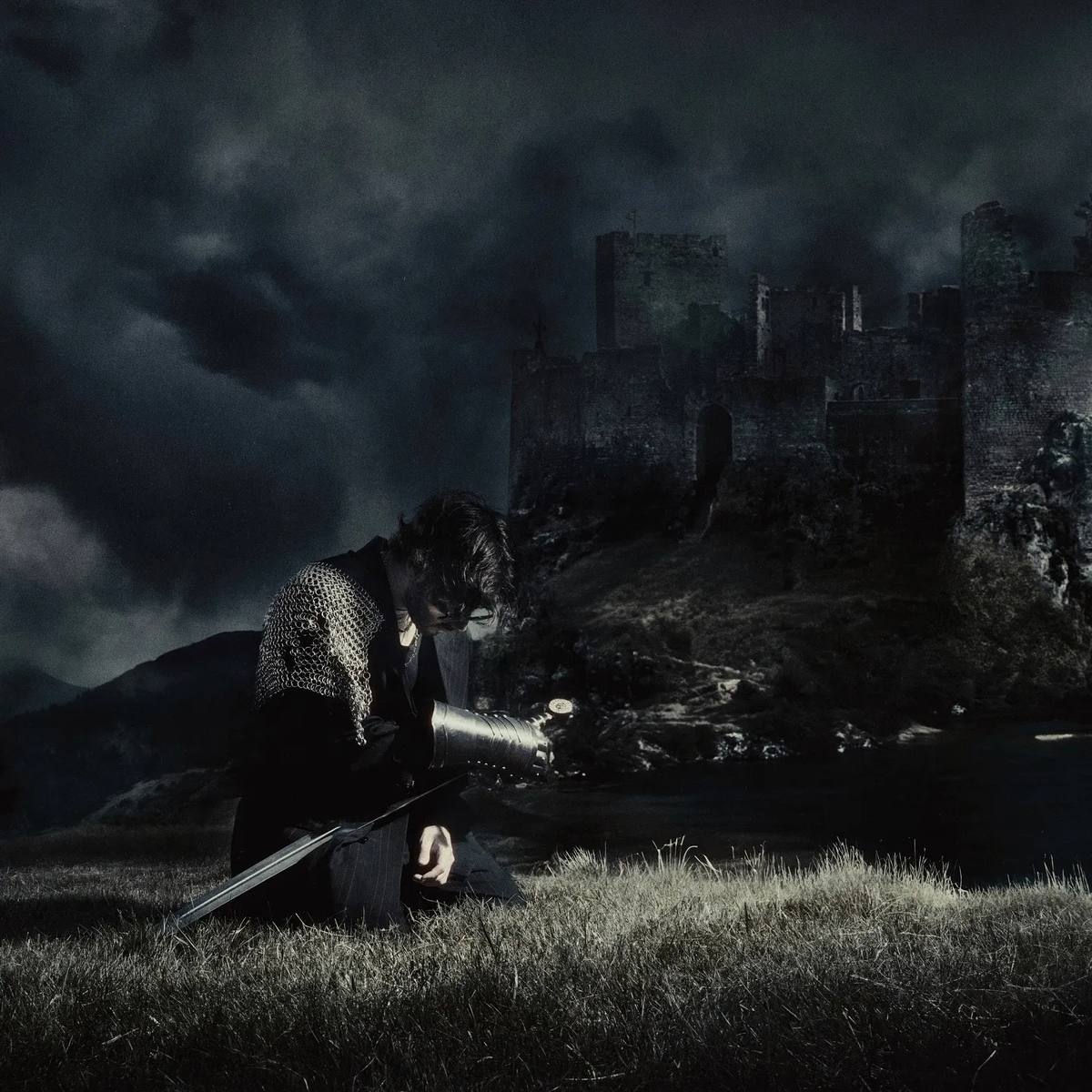 Chris Grey in armor, night sky, castle, press images for 'The Castle Never Falls'
