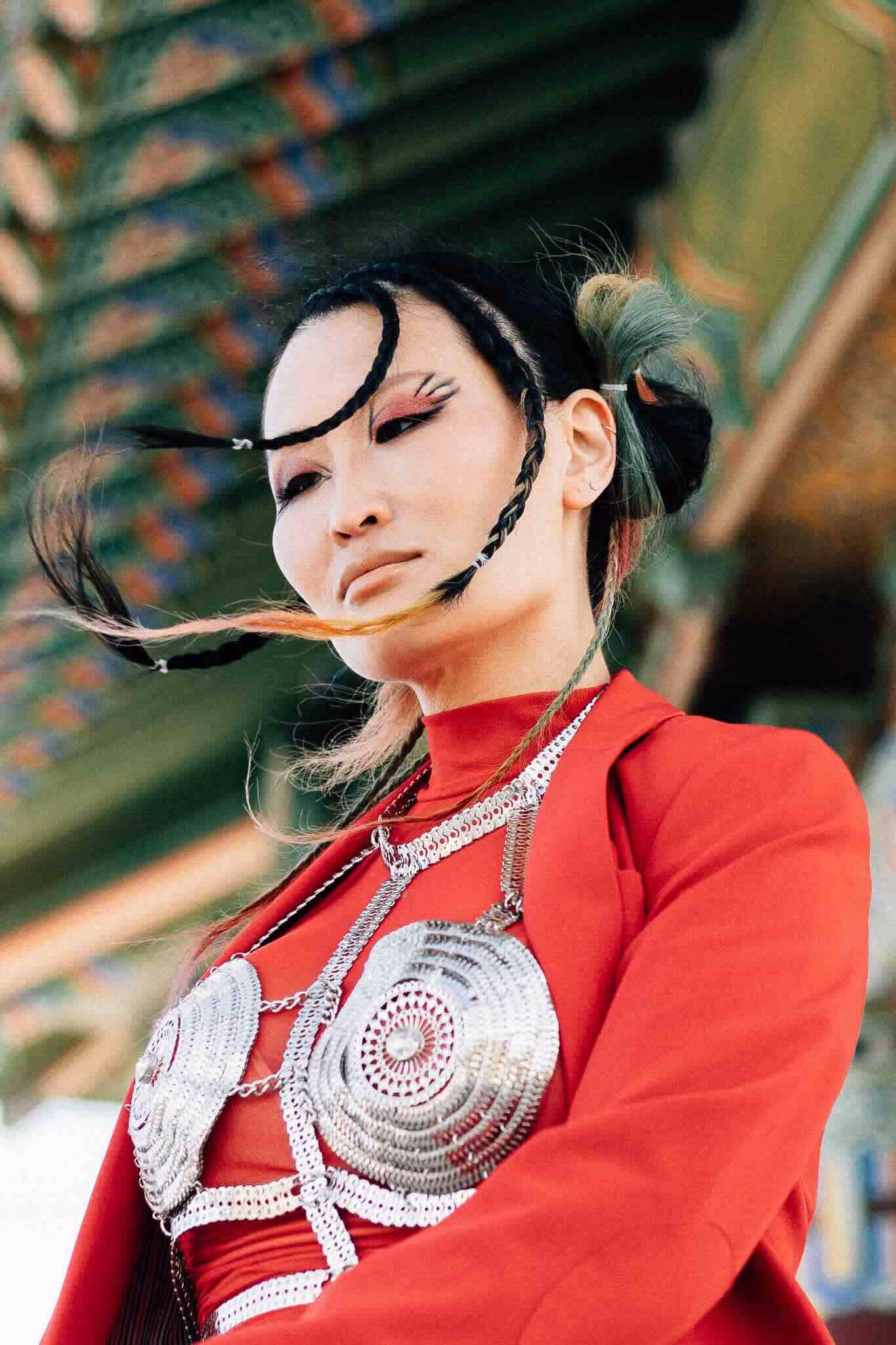 Portrét Nolo Grace v červeném obleku a kovovém braletu