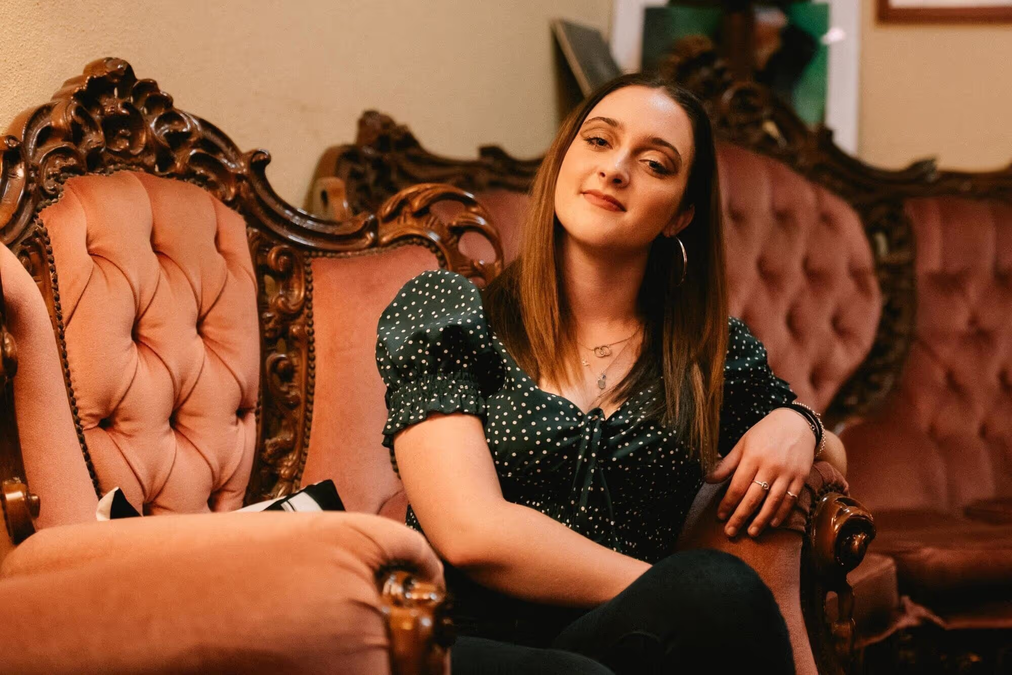 Piper Butcher in polka dot top on the sofa