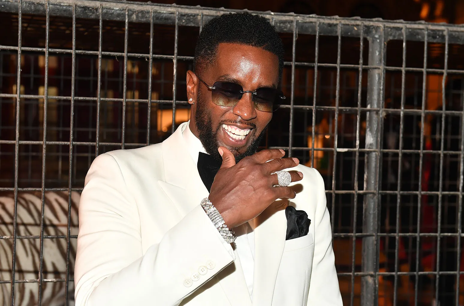 Sean 'Diddy' Combs sonriendo con un traje blanco
